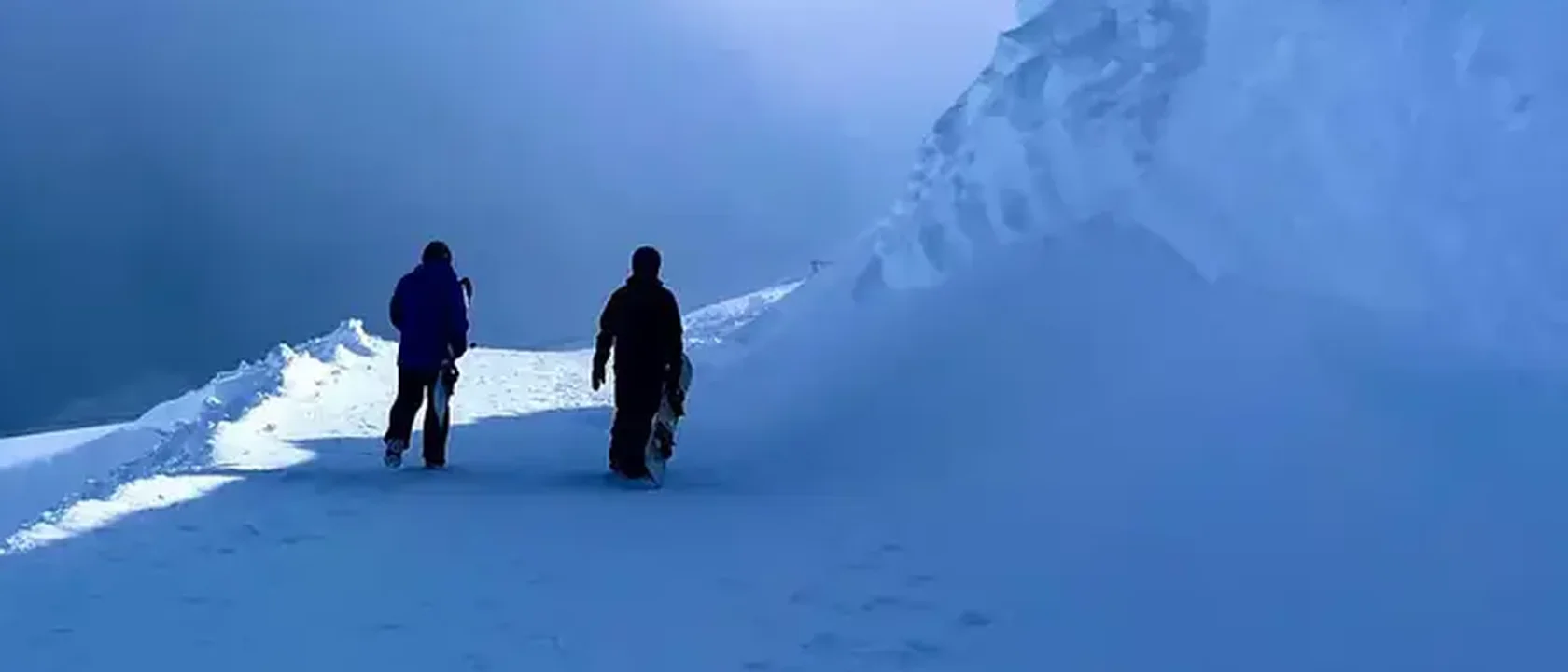 Duas pessoas caminhando na neve, ao longe